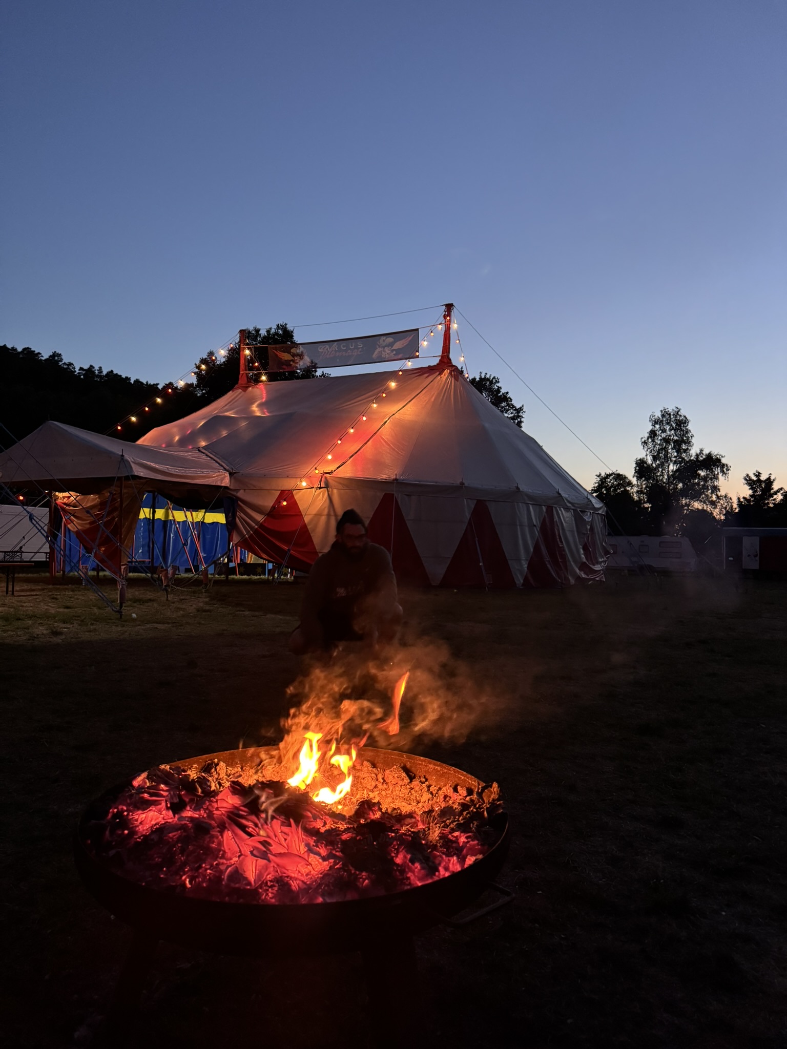 Lagerfeuer vor dem Zirkuszelt in der Dämmerung