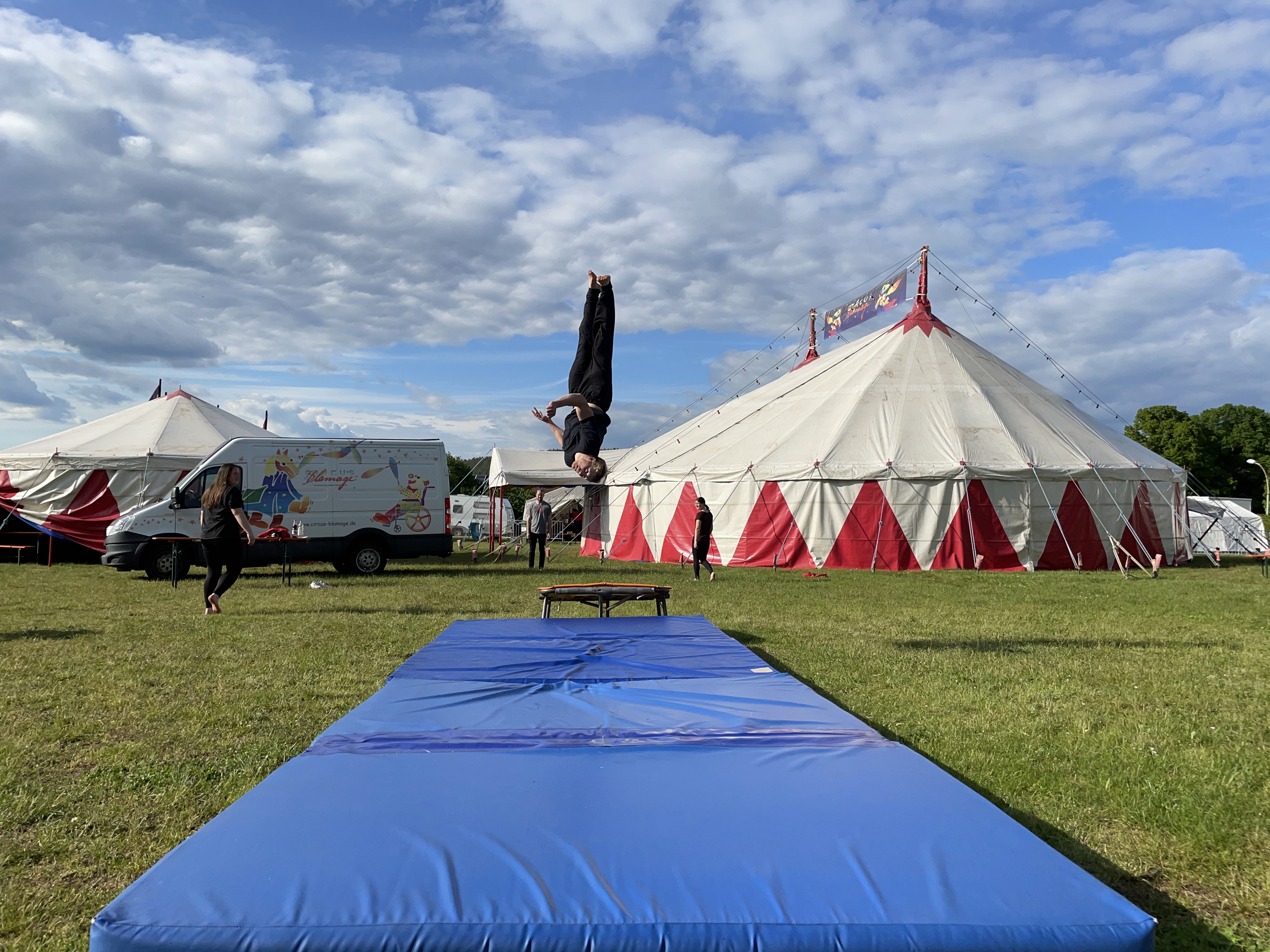 Salto vom Trampolin vor dem Zirkuszelt